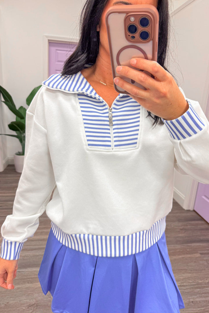 Close up of white and blue 1/4 zip collared pullover