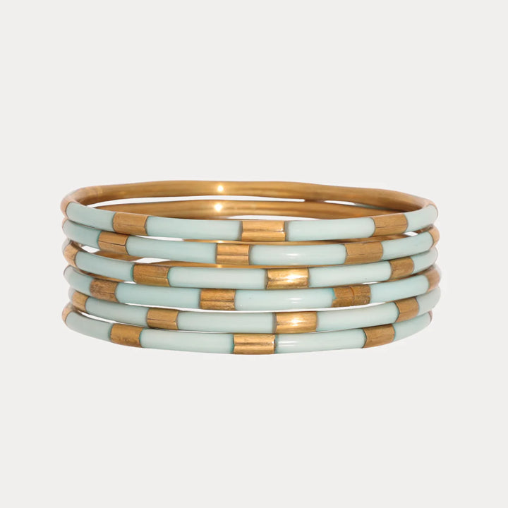 Stack of gold and mint Budhagirl Veda bangle bracelets