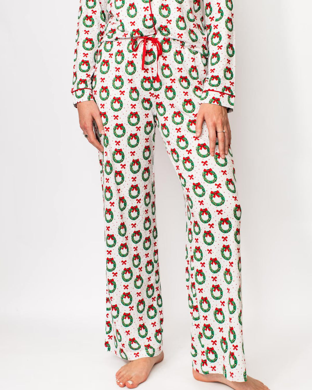 Christmas-themed pajama bottoms with wreath and bow pattern.