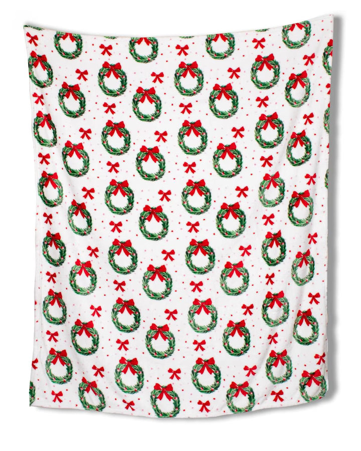 Festive blanket with Christmas wreath and bow pattern on a white background