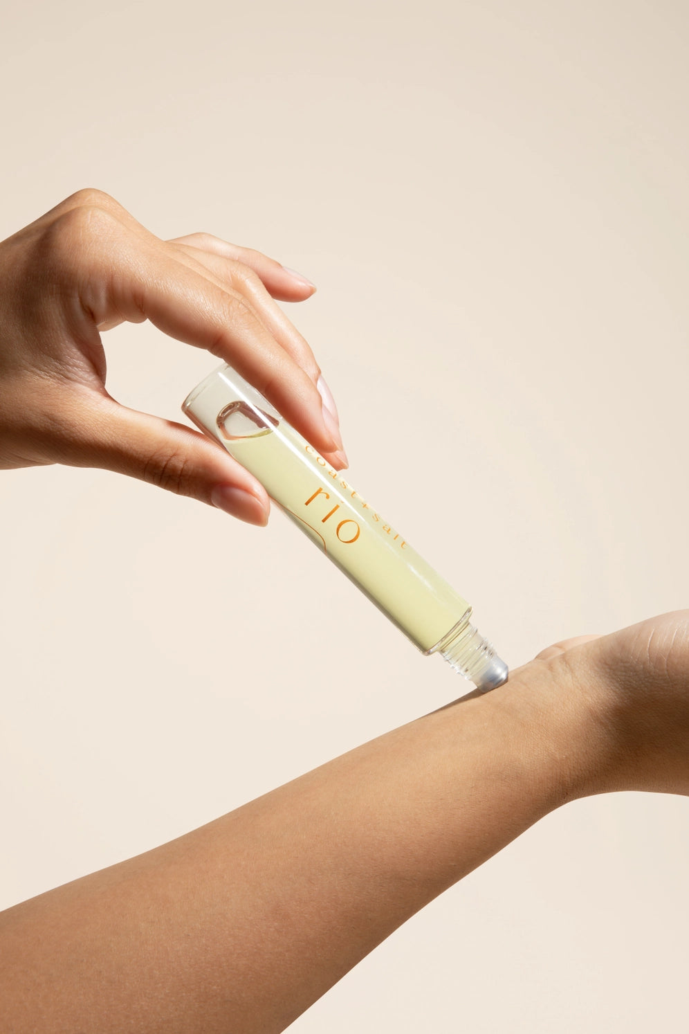 Women applying Coast +Salt Rio Roll-on perfume 