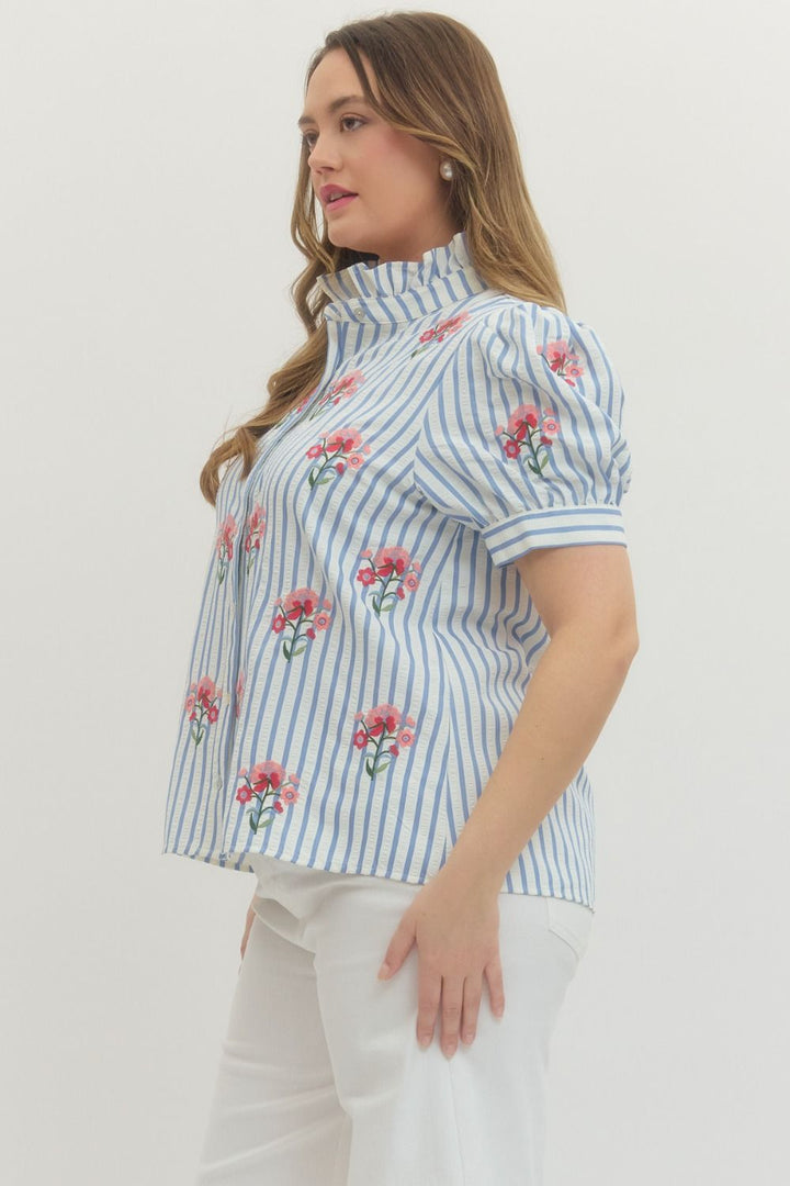 Entro blue and white striped button front top with pink and red embroidered flowers showing a side view of the fit