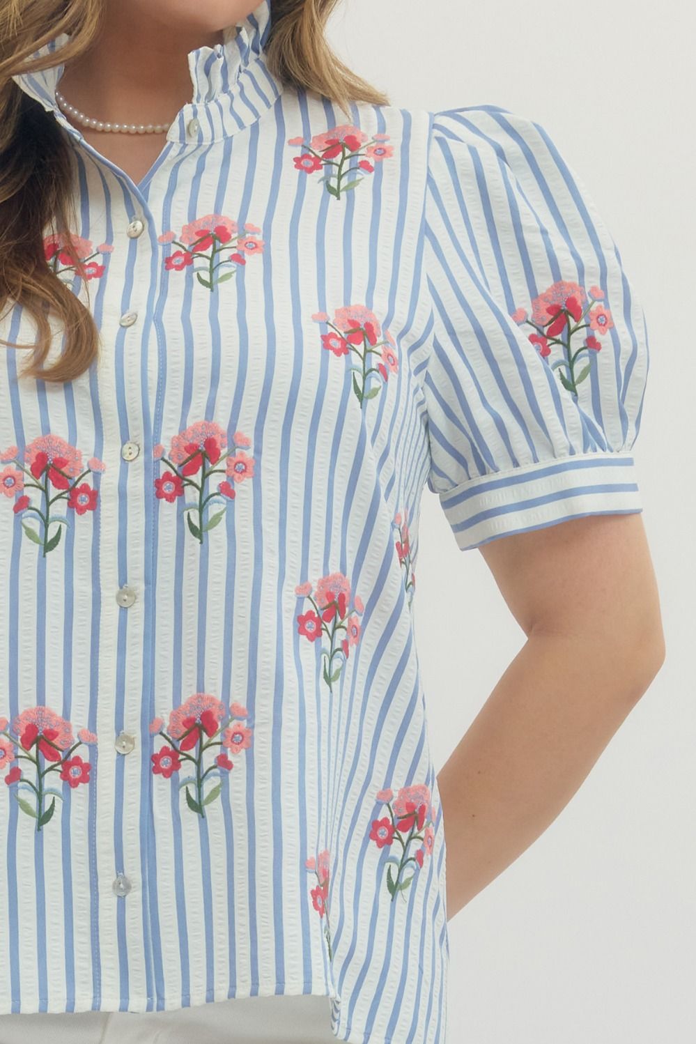 Entro blue and white striped button front top in plus size showing close up view of pink and red embroidered flowers