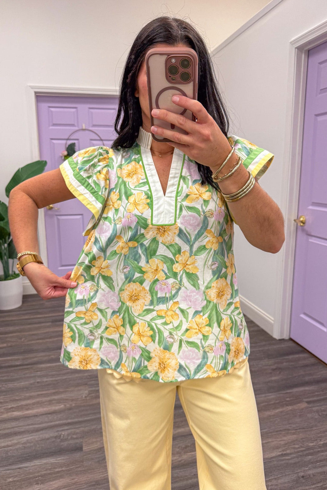 Showing the fit of a Women's yellow and green floral printed short sleeve top