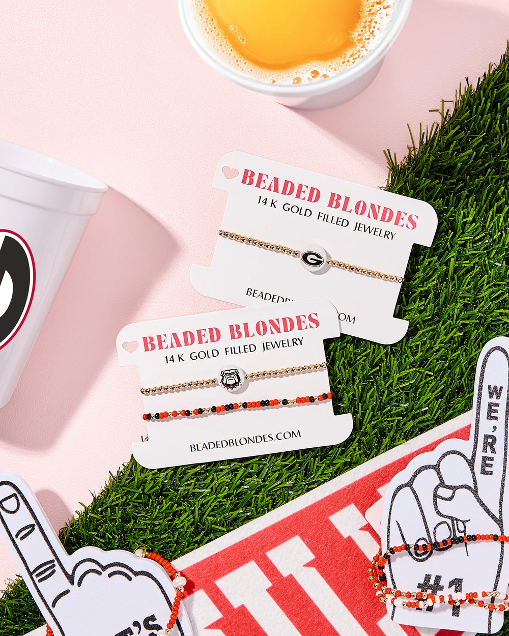 Beaded Blondes jewelry cards with bracelets on a grassy stadium