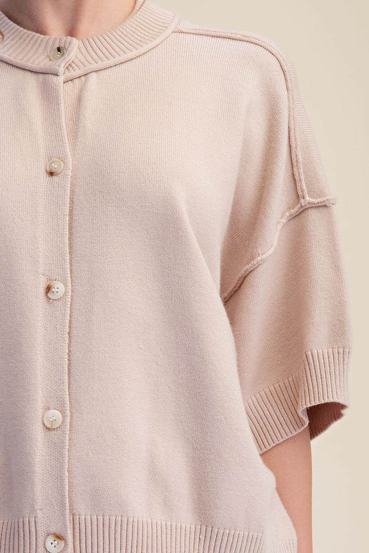 Beige button front knit top with reverse seam details