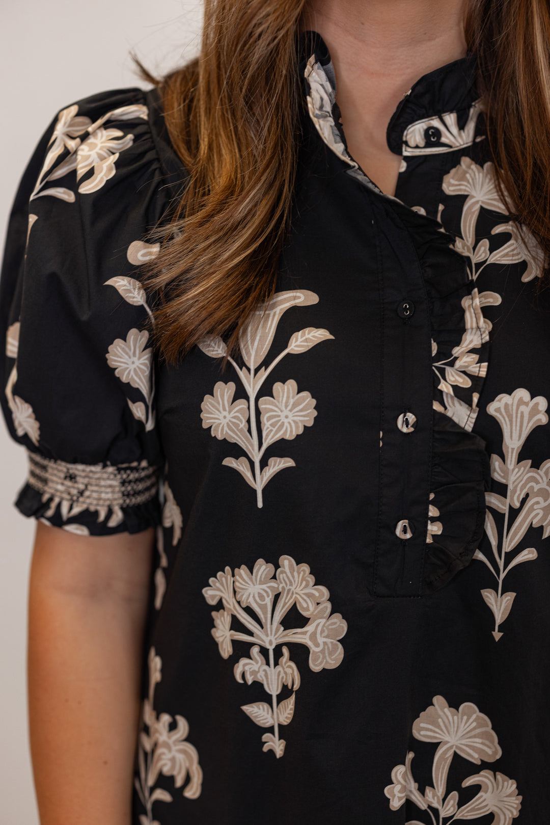 Women's black midi dress with taupe botanical floral print and ruffle and button detail