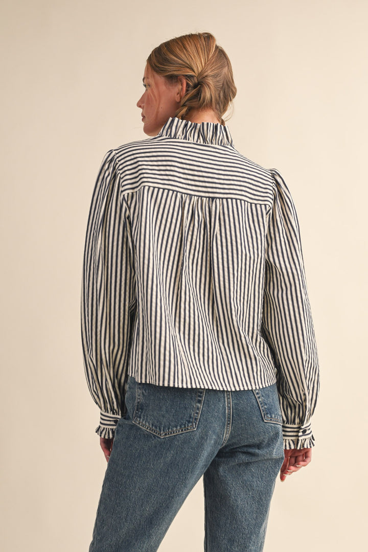 Women's black and cream striped button front top with ruffle trim details by &merci showing back view