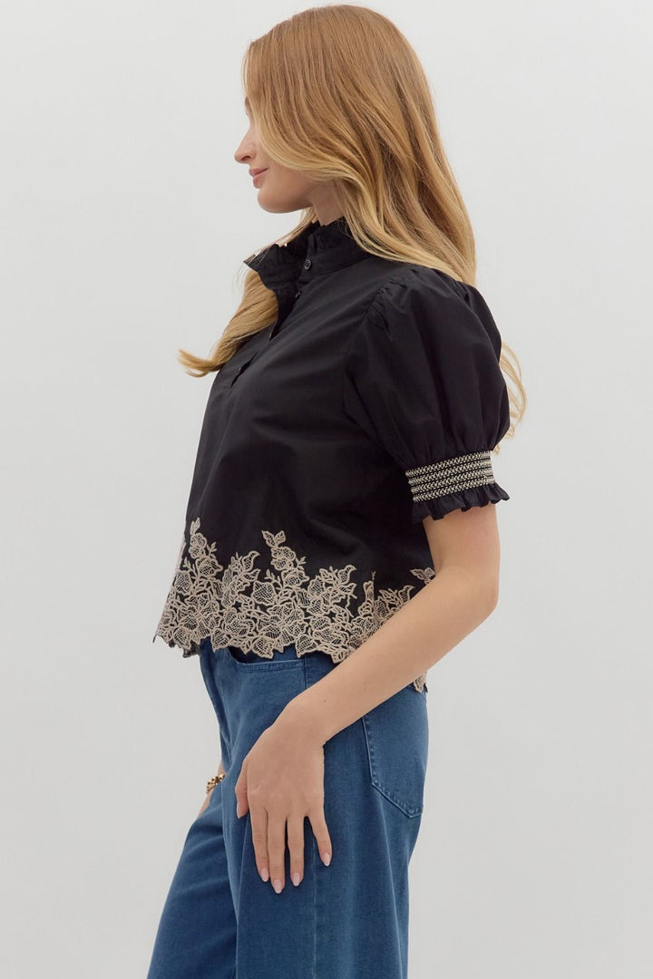Women's black puff sleeve top with cream embroidered floral details by Entro showing side view