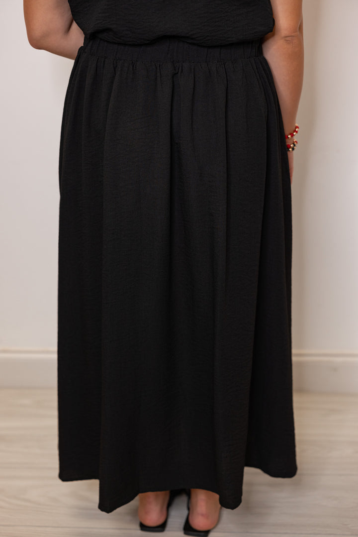 Women's black textured midi skirt with pleats by Entro showing up close back view