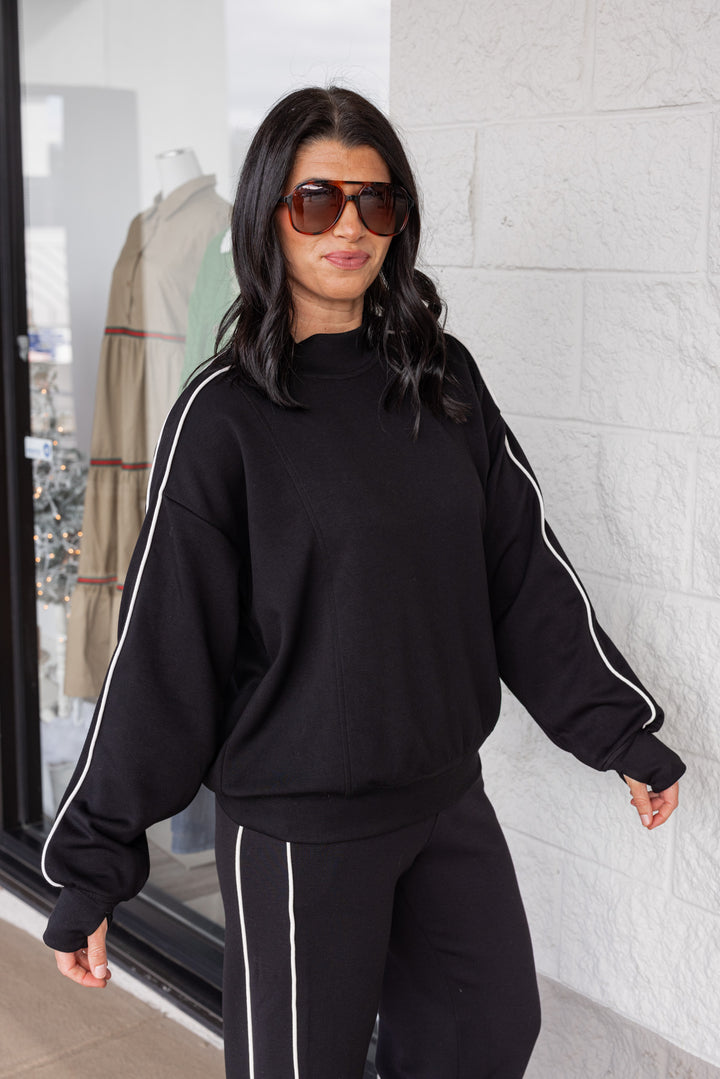 Women's black scuba knit mock neck top by Rae Mode showing slight side view