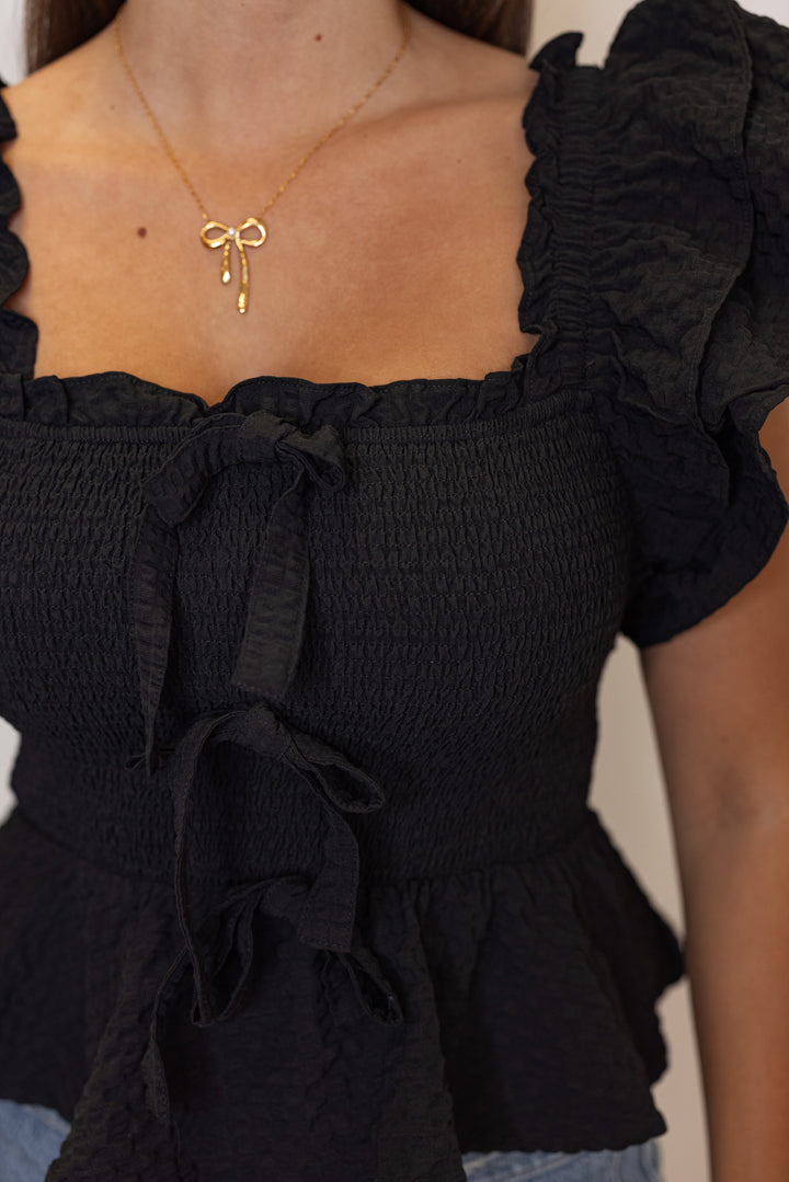 black smocked peplum bow top