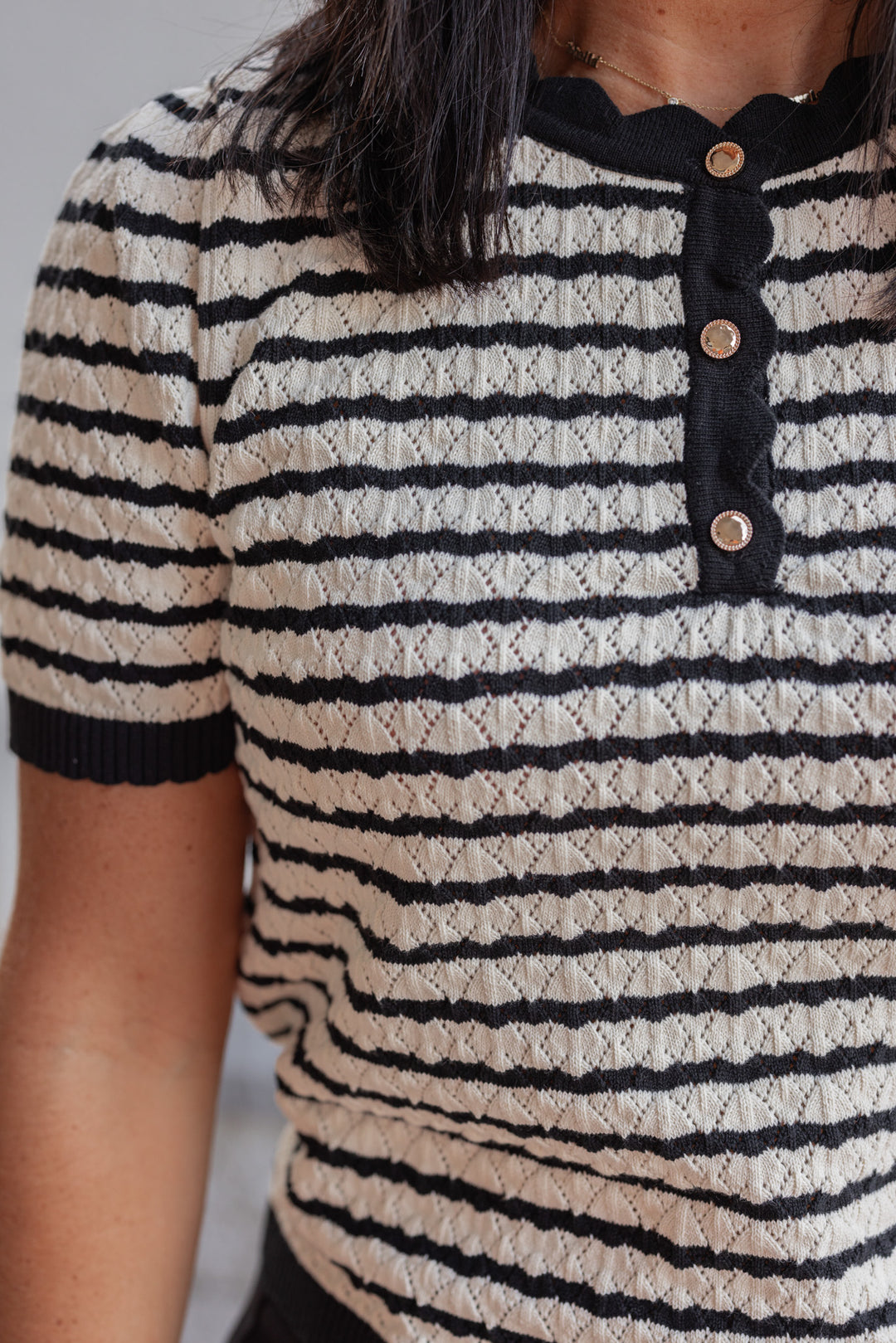 Women's black and cream striped knit top with scalloped trim by Entro showing up close front view