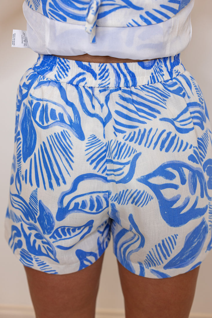 Women's off white sleeveless top and shorts set in blue palm leaf print by &merci showing up close back view of bottoms