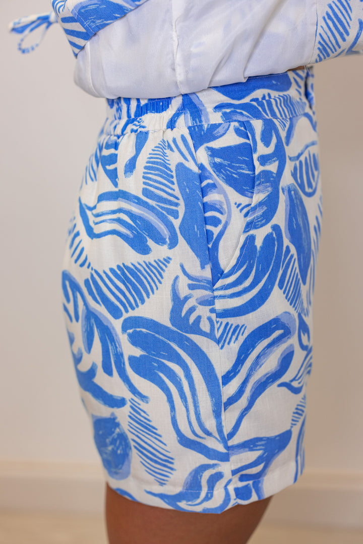 Women's off white sleeveless top and shorts set in blue palm leaf print by &merci showing side view of shorts