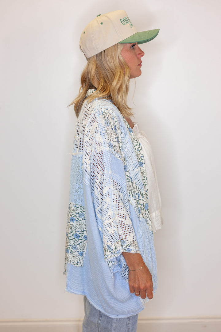 Women's sky blue gauze cardigan top with floral print and floral lace patchwork by POL showing side view