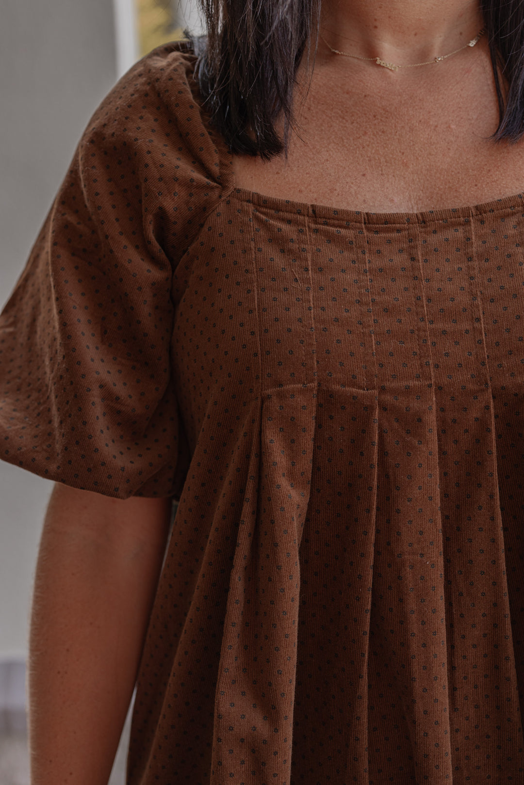 Women's brown pleated corduroy dress with black polkadots by Wishlist showing up close view of pleated details