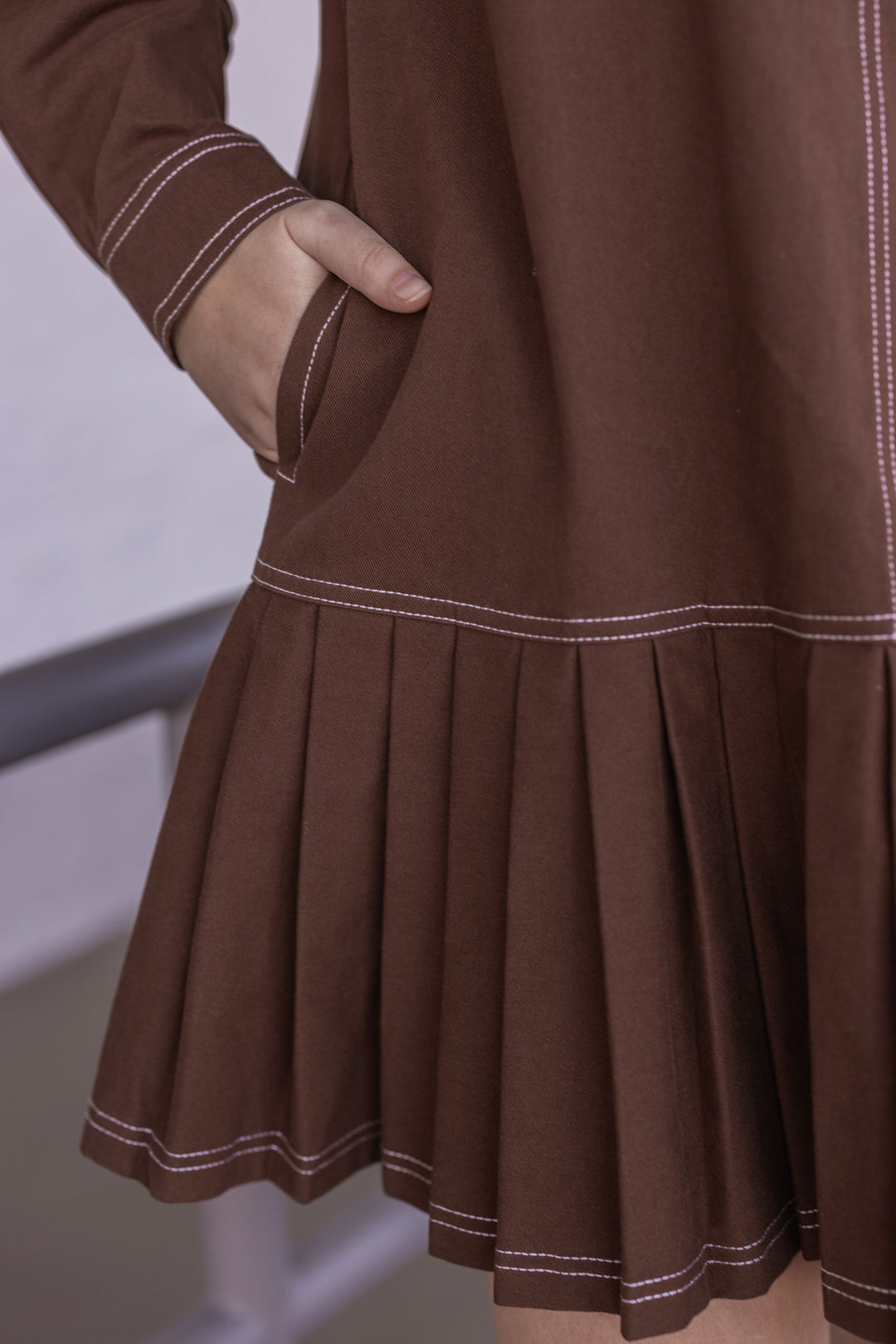 Women's brown denim twill button front dress with cream stitching trim by Entro  showing side pockets