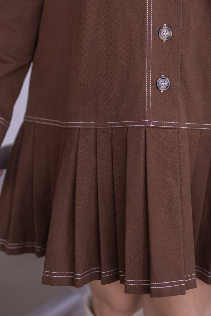 Women's brown denim twill button front dress with cream stitching trim by Entro showing pleated bottom hem