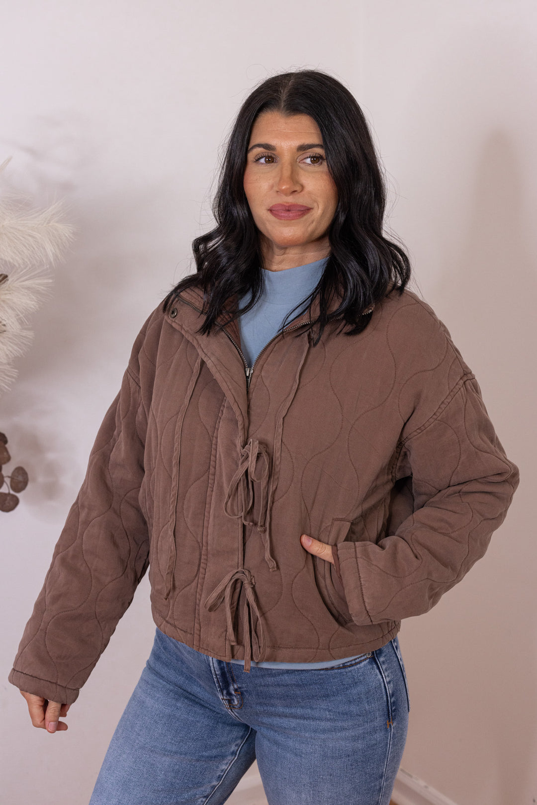 Women's washed brown quilted puffer jacket with bow ties down the front by Blu Pepper showing up close, slightly angled front view