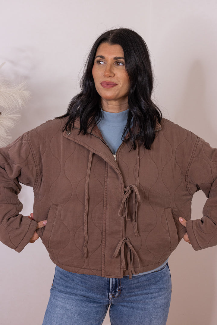 Women's washed brown quilted puffer jacket with bow ties down the front by Blu Pepper showing true to size fit