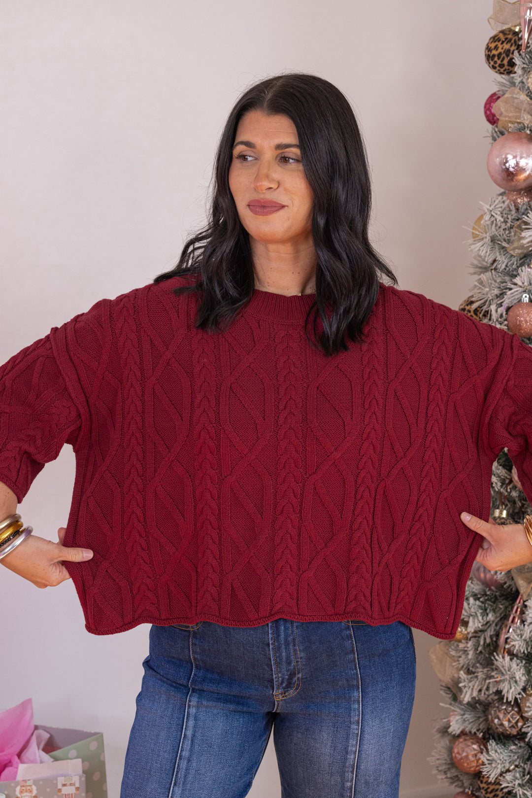 Women's burgundy cable knit cropped sweater by Entro showing semi-cropped length