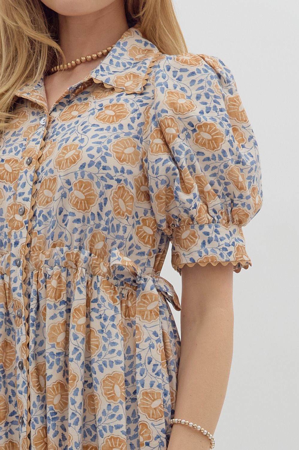 Women's cream button front midi dress with caramel and blue floral print by Entro showing side tie detailing