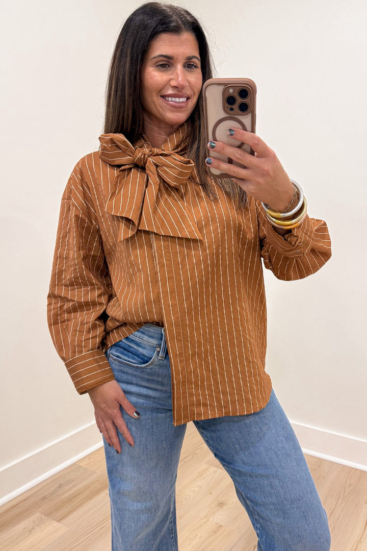 caramel and taupe striped long sleeve flap covered button front top with adjustable bow tie mock neckline