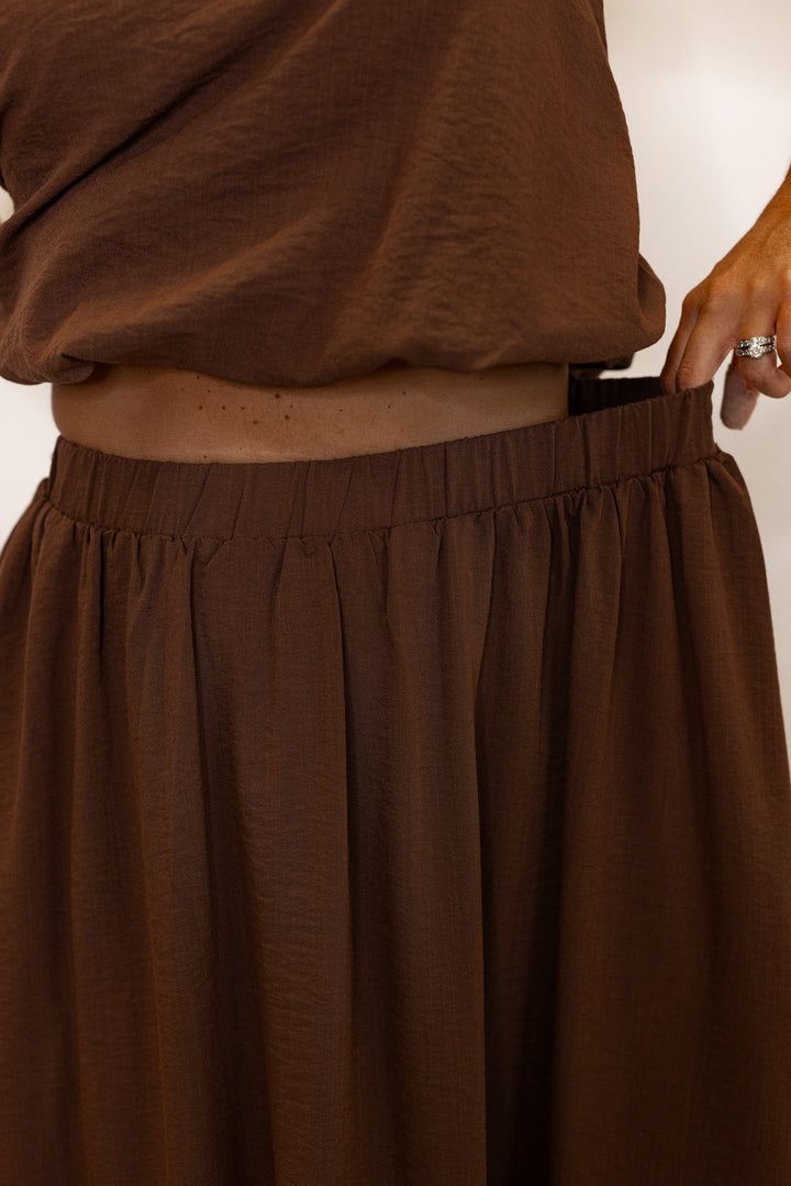Women's espresso brown textured midi skirt with pleats by Entro showing elastic waistband