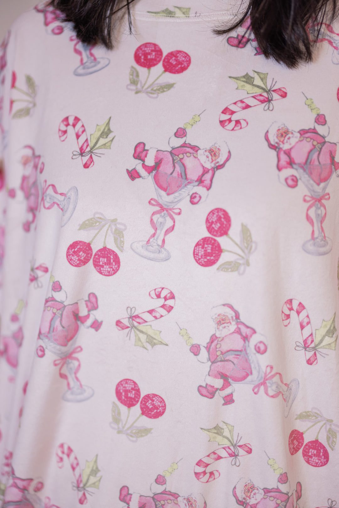 Women's white pajama lounge top with  bow tie details by Peach Love California showing up close look at holiday pink cherry santa print