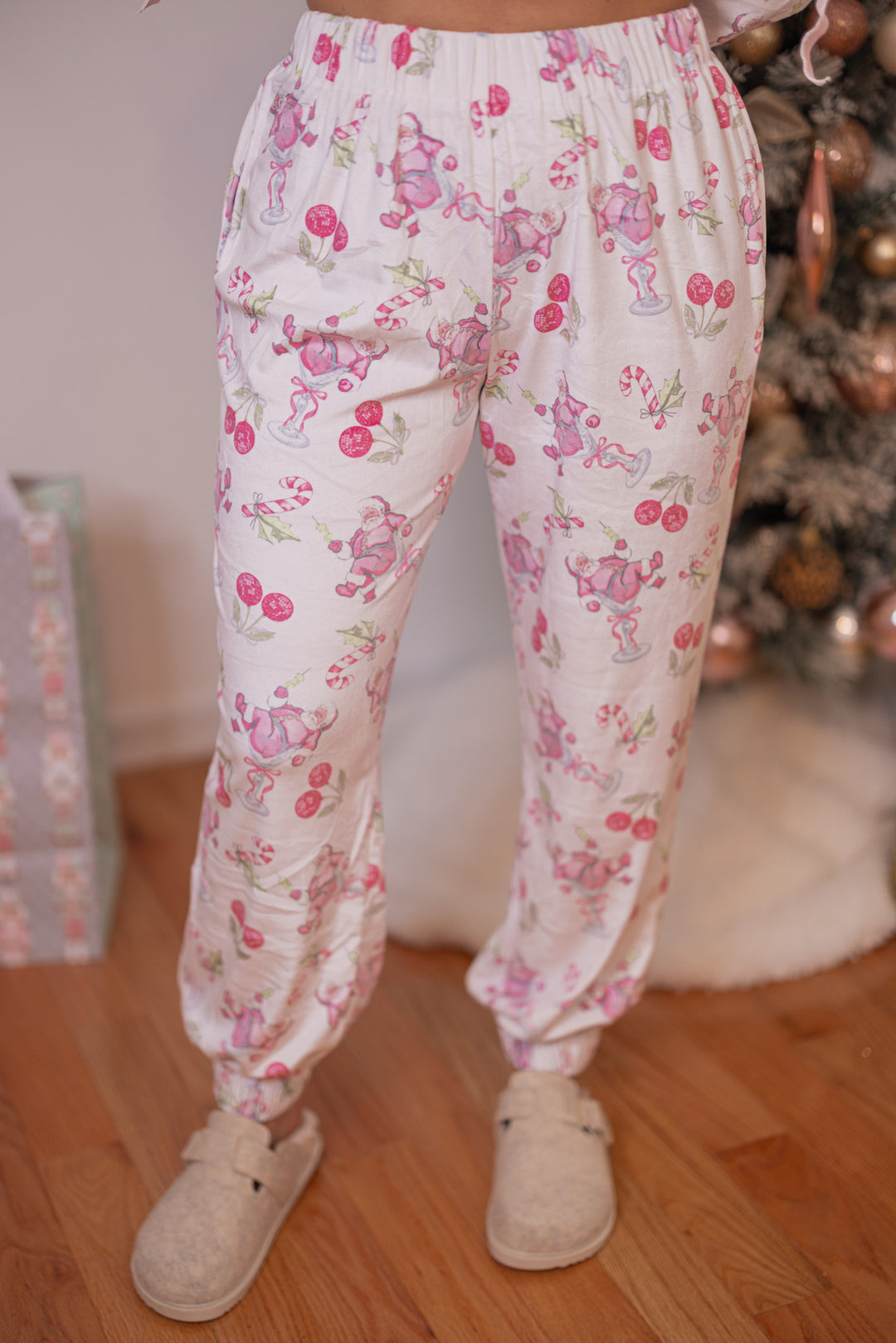 Women's white pajama lounge jogger pants with pink cherry santa print by Peach Love California showing up close front view