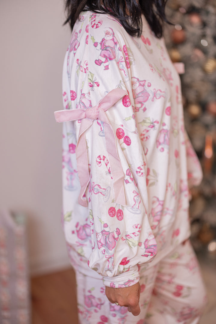 Women's white pajama lounge top with pink cherry santa print and bow tie details by Peach Love California showing side view