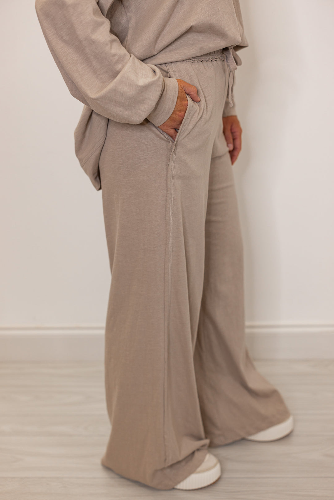 Side view of beige wide leg active pants with side pockets