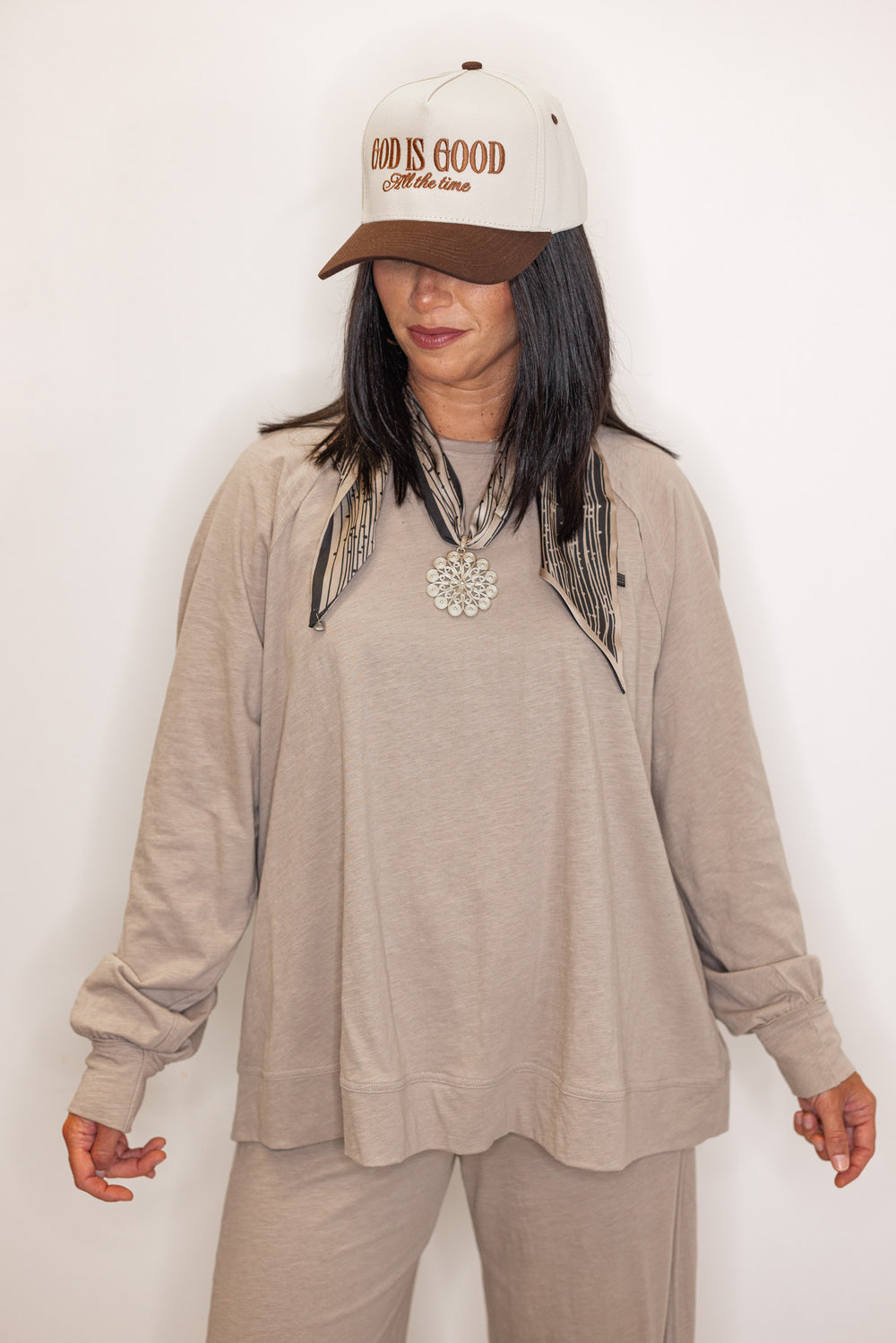 Women's beige long sleeve crew neck top, with "God is Good" hat