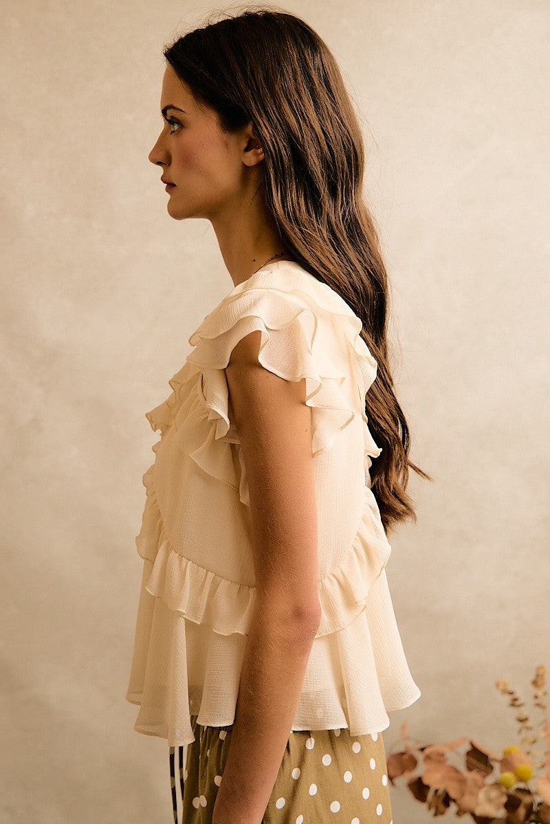 Cream chiffon top with ruffle details and a flowy silhouette