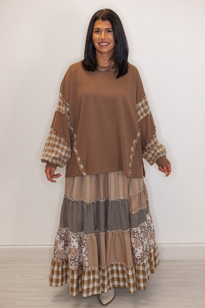 Women's mocha brown knit boho top with plaid detailing shown untucked with printed maxi skirt