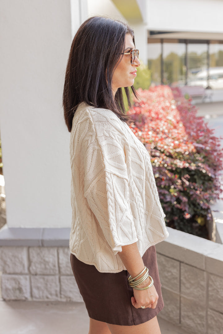 Women's ecru cable knit cropped sweater by Entro showing up close side view