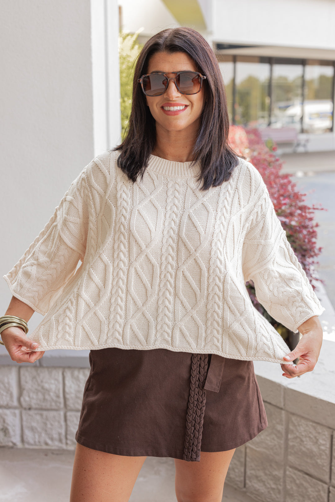 Women's ecru cable knit cropped sweater by Entro showing cropped length