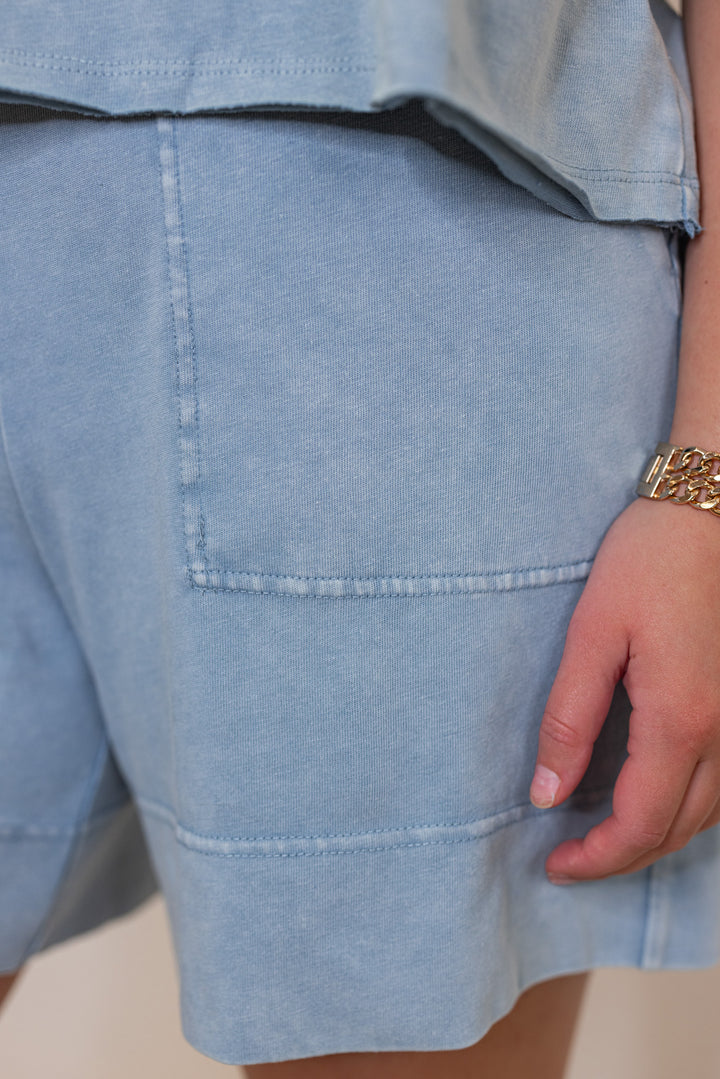 Women's mineral washed utility blue knit shorts by Rae Mode showing showing up close view of front pocket detail