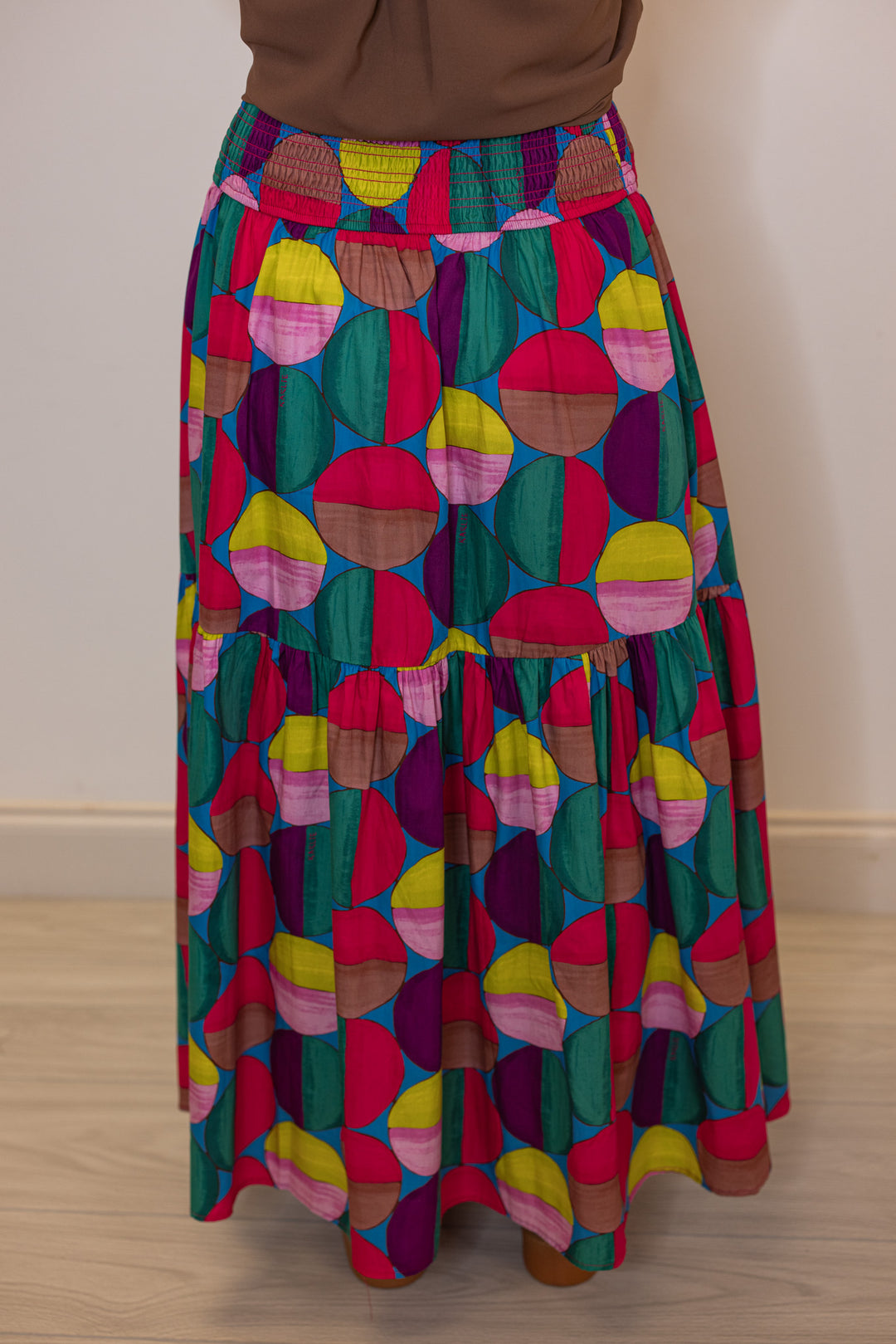 Women's smocked hot pink and multicolor print tiered poplin maxi skirt by Karlie showing back view
