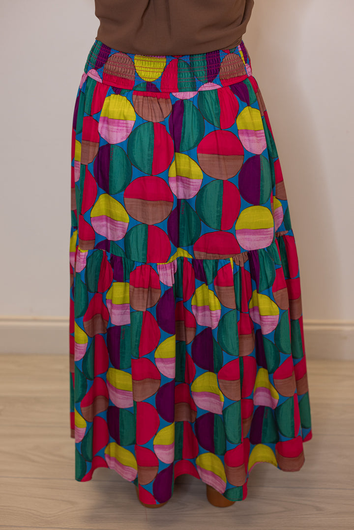 Women's smocked hot pink and multicolor print tiered poplin maxi skirt by Karlie showing back view