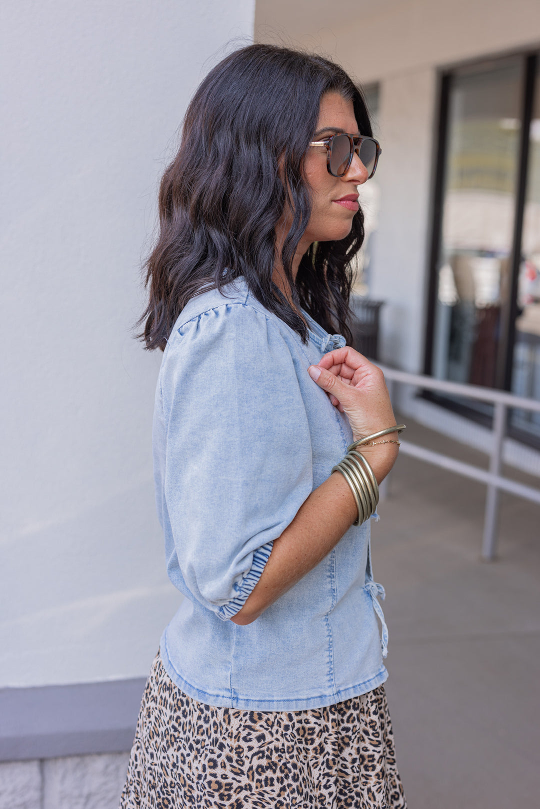Blue denim top with bow tie closures down the open front peek a boo bodice by Wishlist showing up close side view