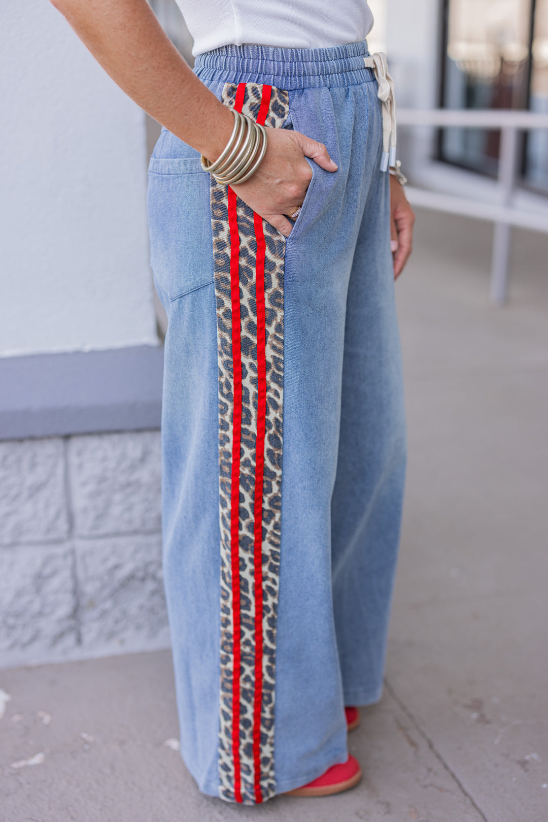 Women's blue denim wide leg pants with red ribbon and brown leopard print sides by Easel