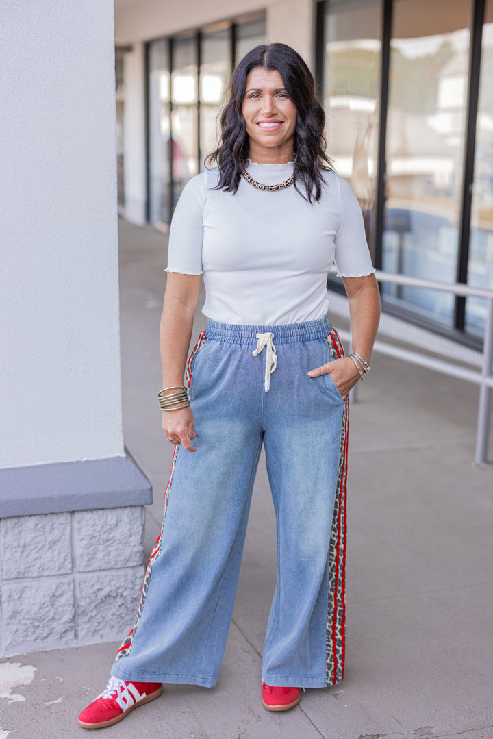 Women's blue denim wide leg pants with red ribbon and brown leopard print sides by Easel showing full front view