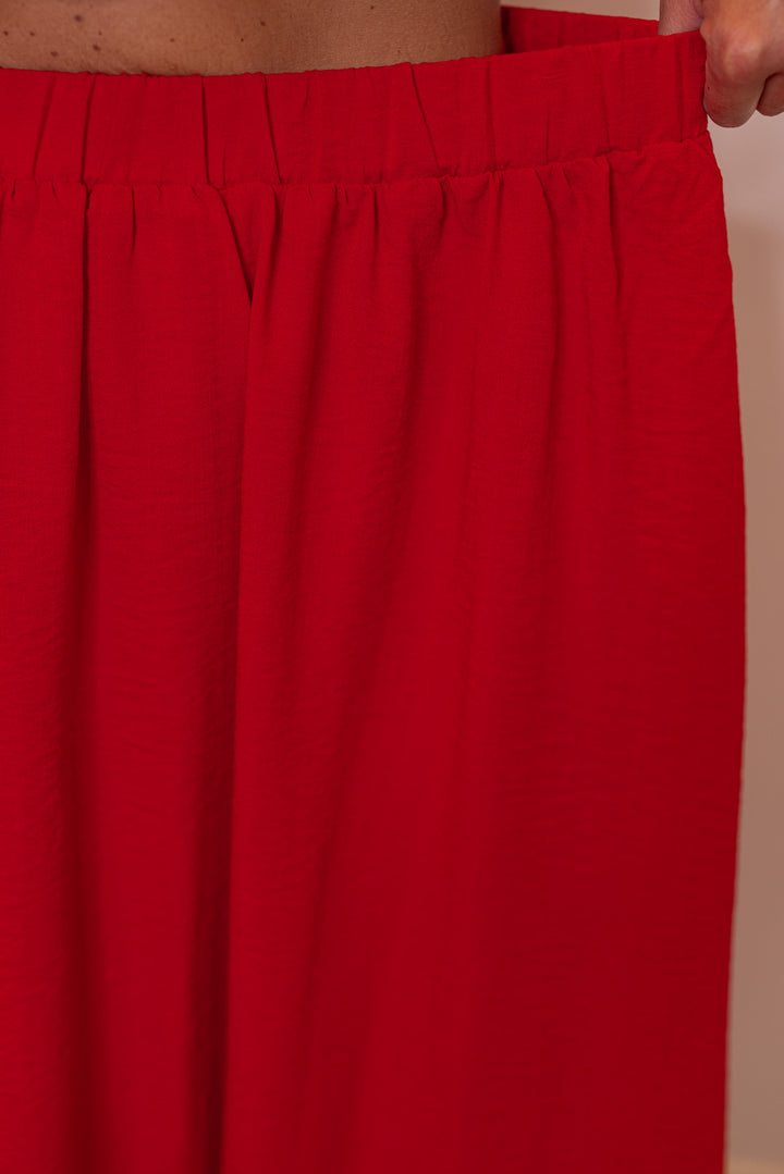 Women's red textured midi skirt with pleats by Entro showing elastic waistband