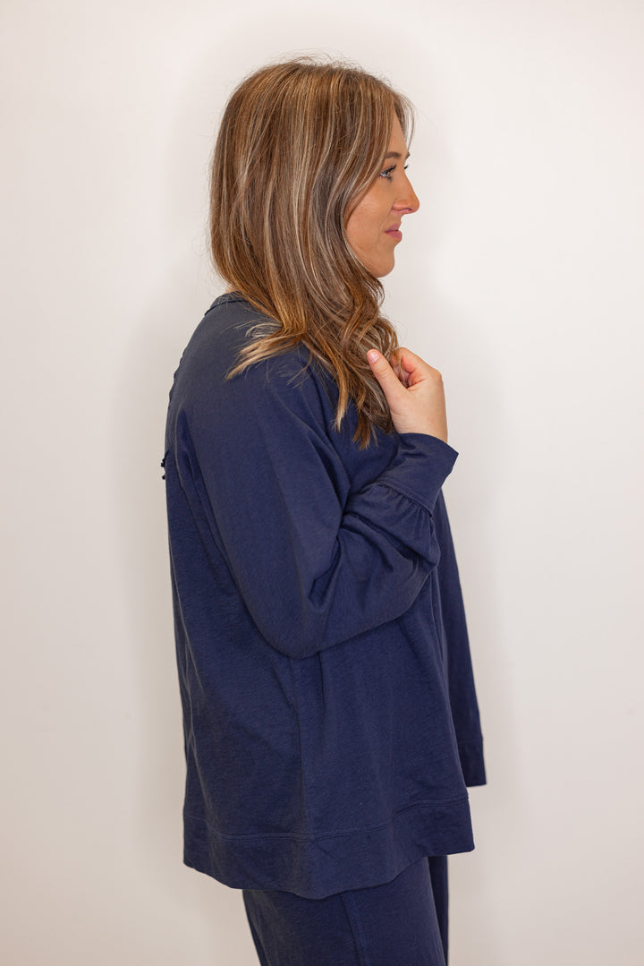 Side view of Women's navy blue athleisure long sleeve tee and pants set