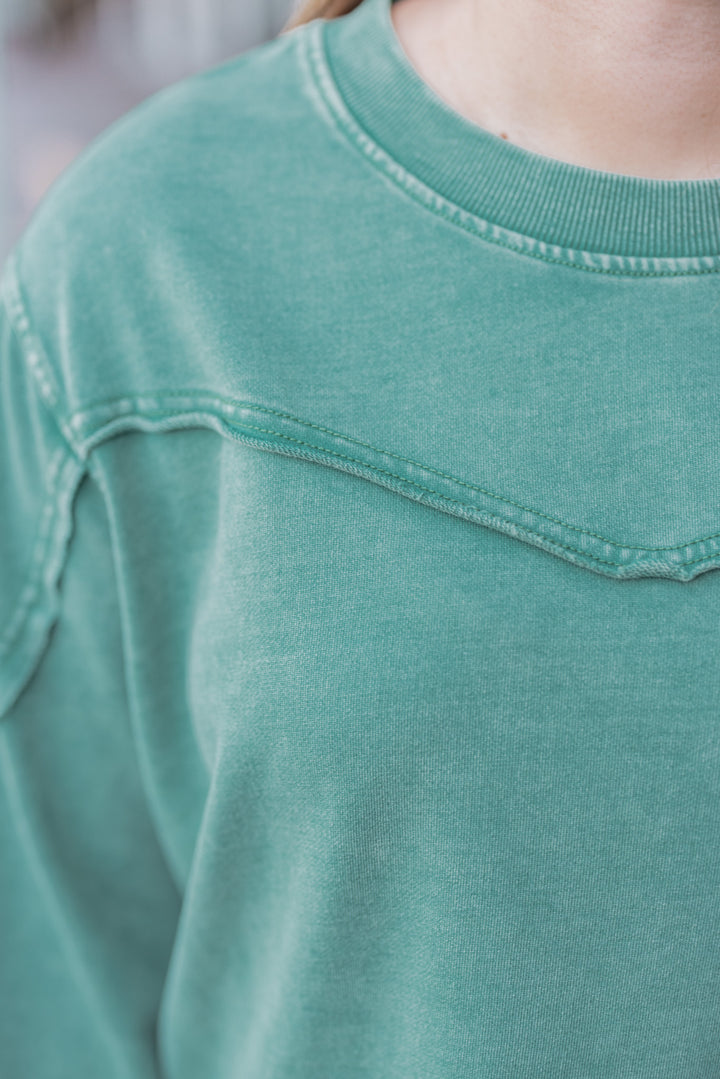 Women's mineral washed pine green terry knit pullover by Easel showing raw/reverse seam details