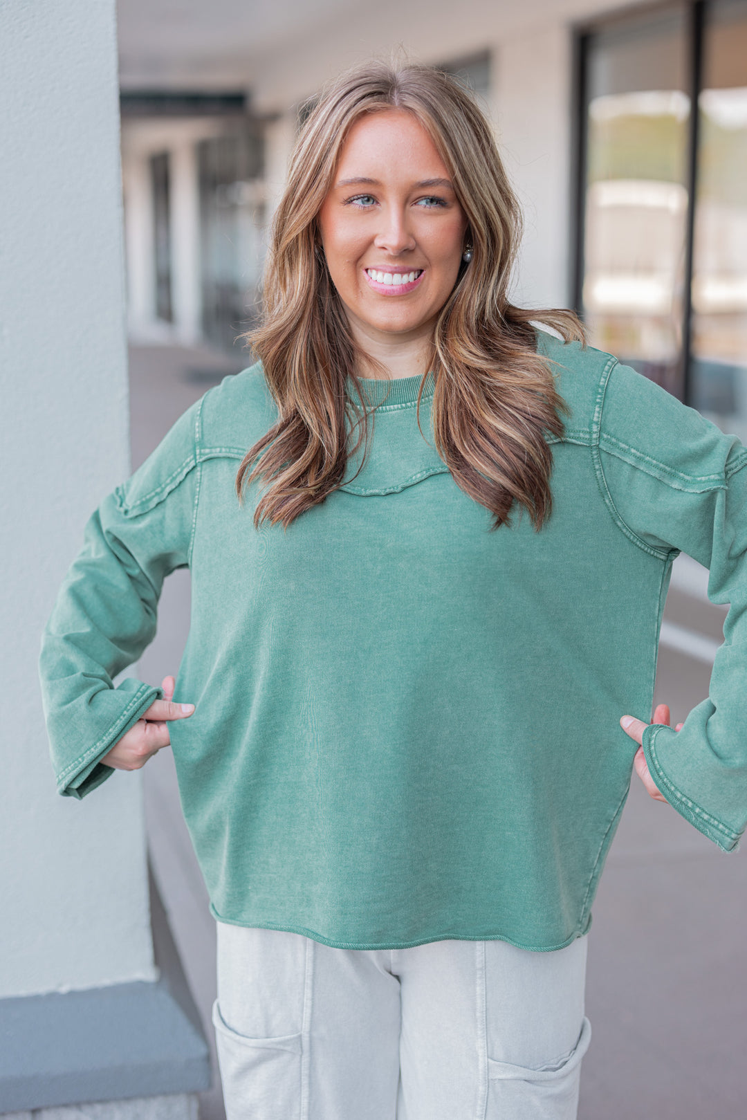 Women's mineral washed pine green terry knit pullover with raw/reverse seam details by Easel showing relaxed silouhette