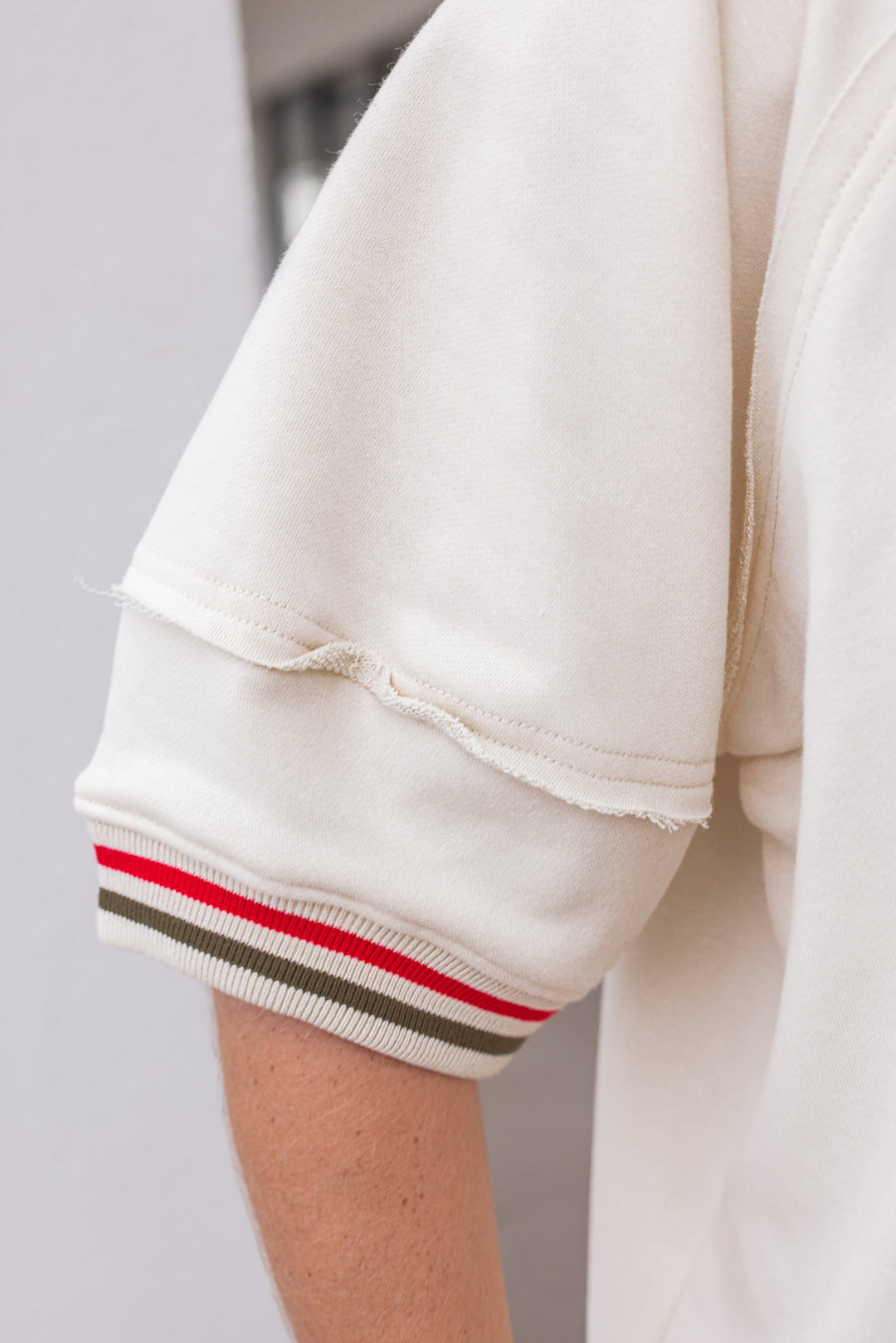 Women's ecru french terry knit top with olive and red striped trim by Entro showing up close view of sleeve