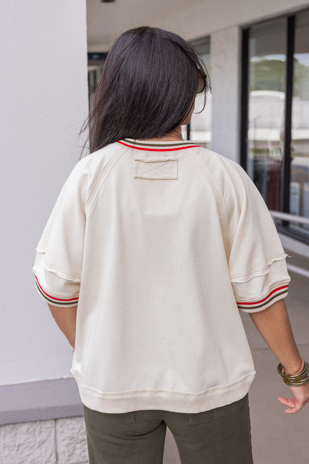 Women's ecru french terry knit top with olive and red striped trim by Entro showing back view